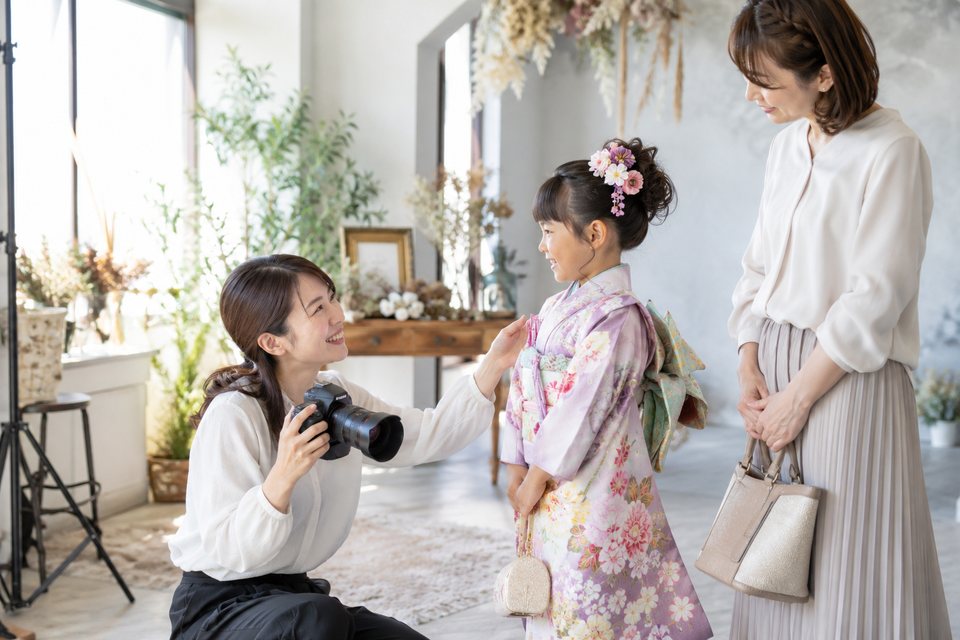 子どもの撮影前に相談するスタッフ（AI生成イメージ）