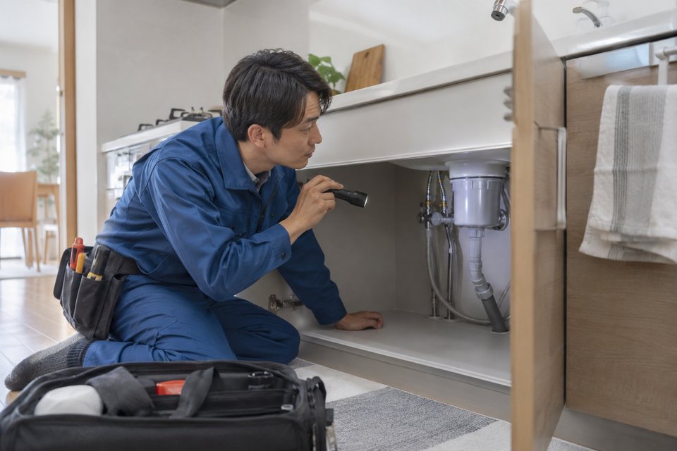 水回りの設備を確認する修理担当者の撮影見本(AI生成)