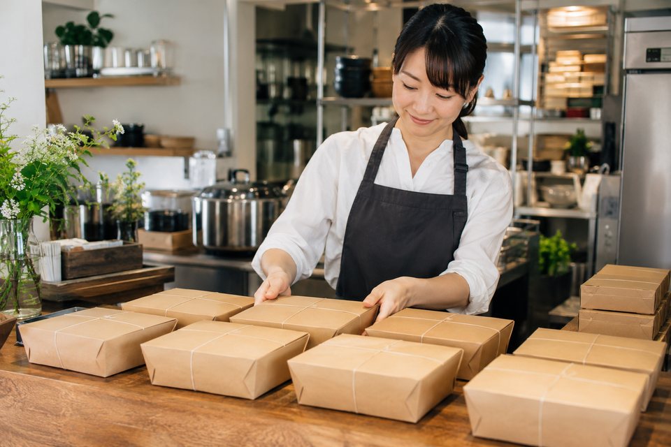 数量に合わせて準備する弁当の受け渡し（AI生成イメージ）